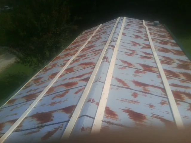 Rusted metal roof panels with new wood purlins before replacement — Storm Damage Roof Repair in Markleysburg by Roofing Brothers