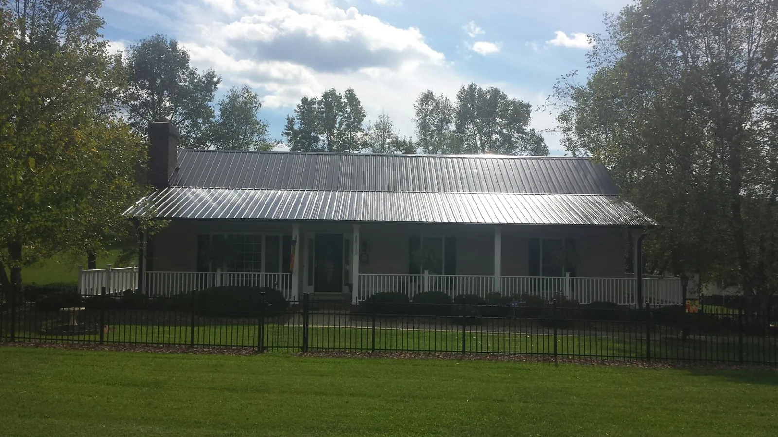 Gray metal roof on a brick ranch with a full width front porch — Gutter Guard Installation work by our crew in Markleysburg