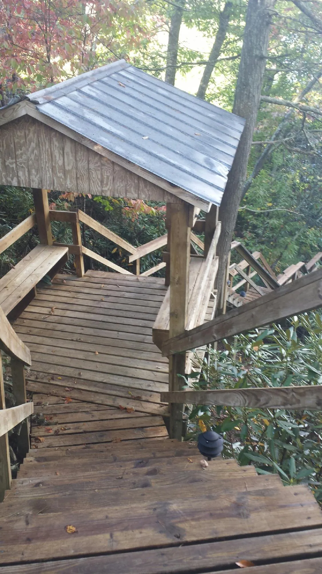Metal roofed shelter over wooden steps on a wooded walkway — Skylight Repair & Installation work by our crew in Markleysburg