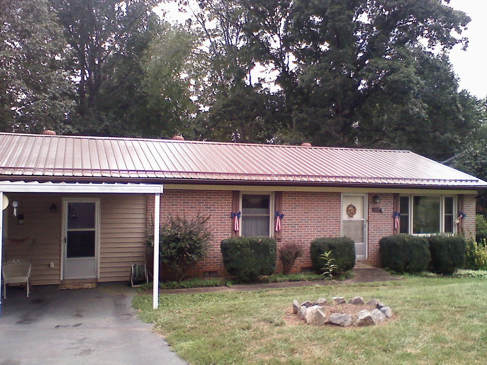 Bronze metal roof and carport on a brick ranch home — Roof Repair work by our crew in Markleysburg